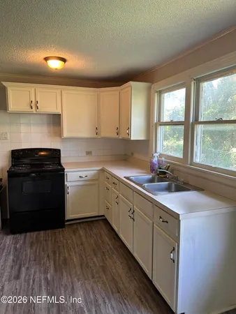 a kitchen with a sink stove and cabinets