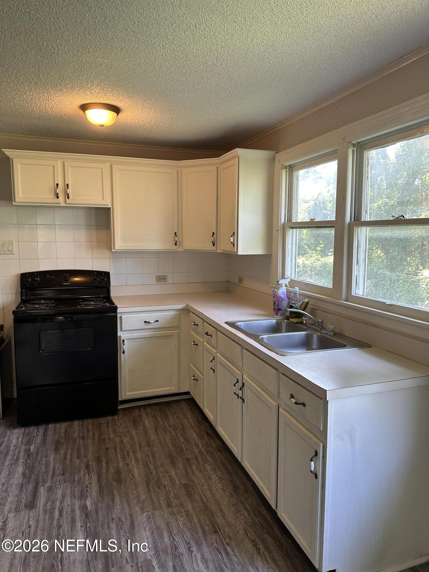 5620 Bagnal Road Jacksonville, FL 32205 - Photo 22 of 31 a kitchen with a sink stove and cabinets