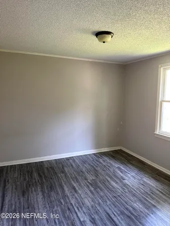 a view of a room with wooden floor and a window