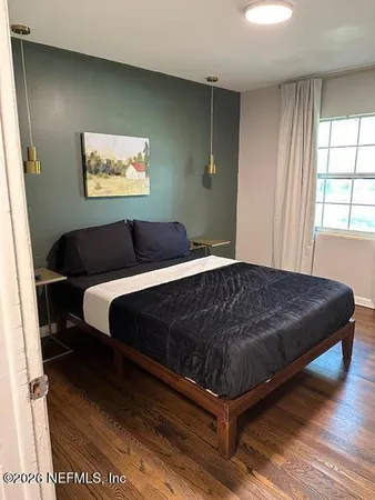 a bed sitting in a bedroom next to a window