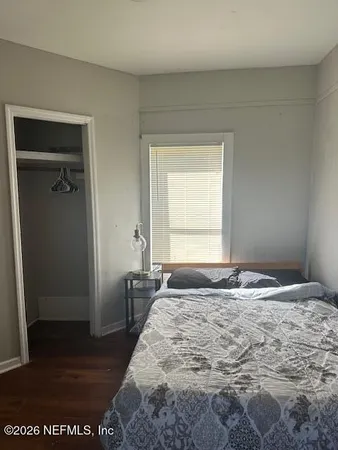 a bedroom with a bed and wooden floor