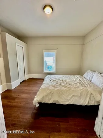 a bedroom with a bed and wooden floor