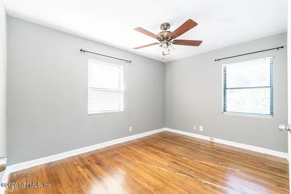 a view of a big room with wooden floor and windows