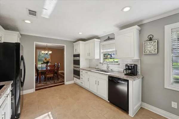 a kitchen with granite countertop a refrigerator stove and sink