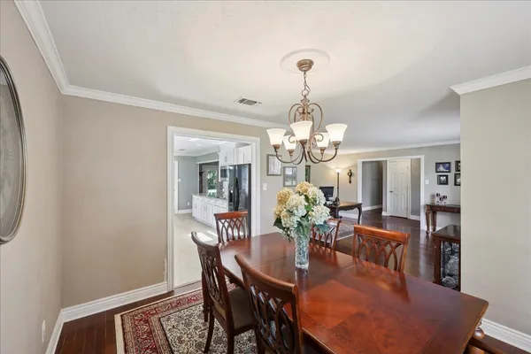 a view of a dining room with furniture a chandelier and wooden floor