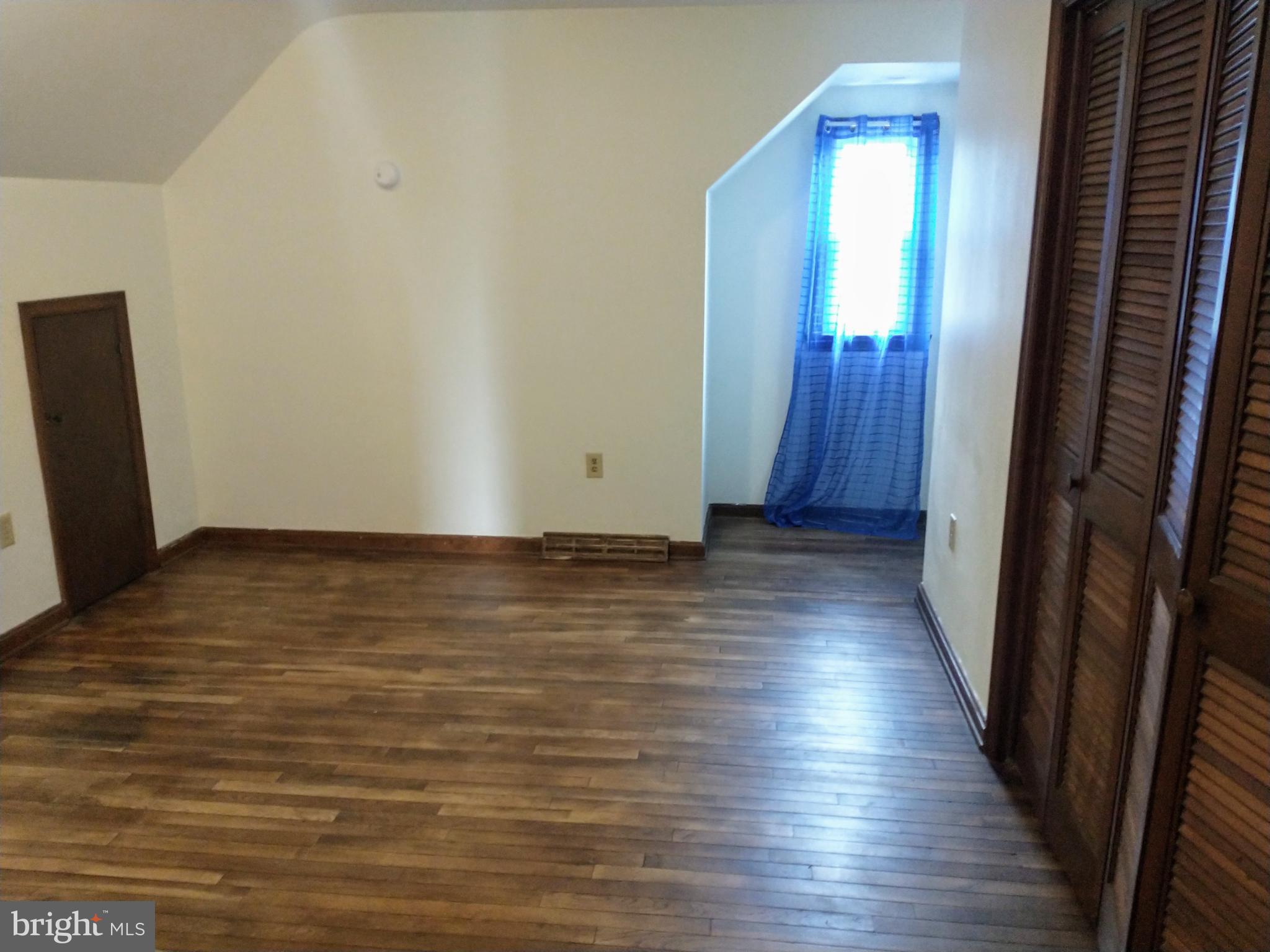 512 Mifflin Boulevard Reading, PA 19607 - Photo 27 of 57 a view of an empty room with wooden floor and a window