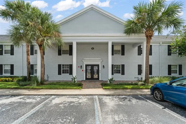 a front view of a house with a yard and potted plants