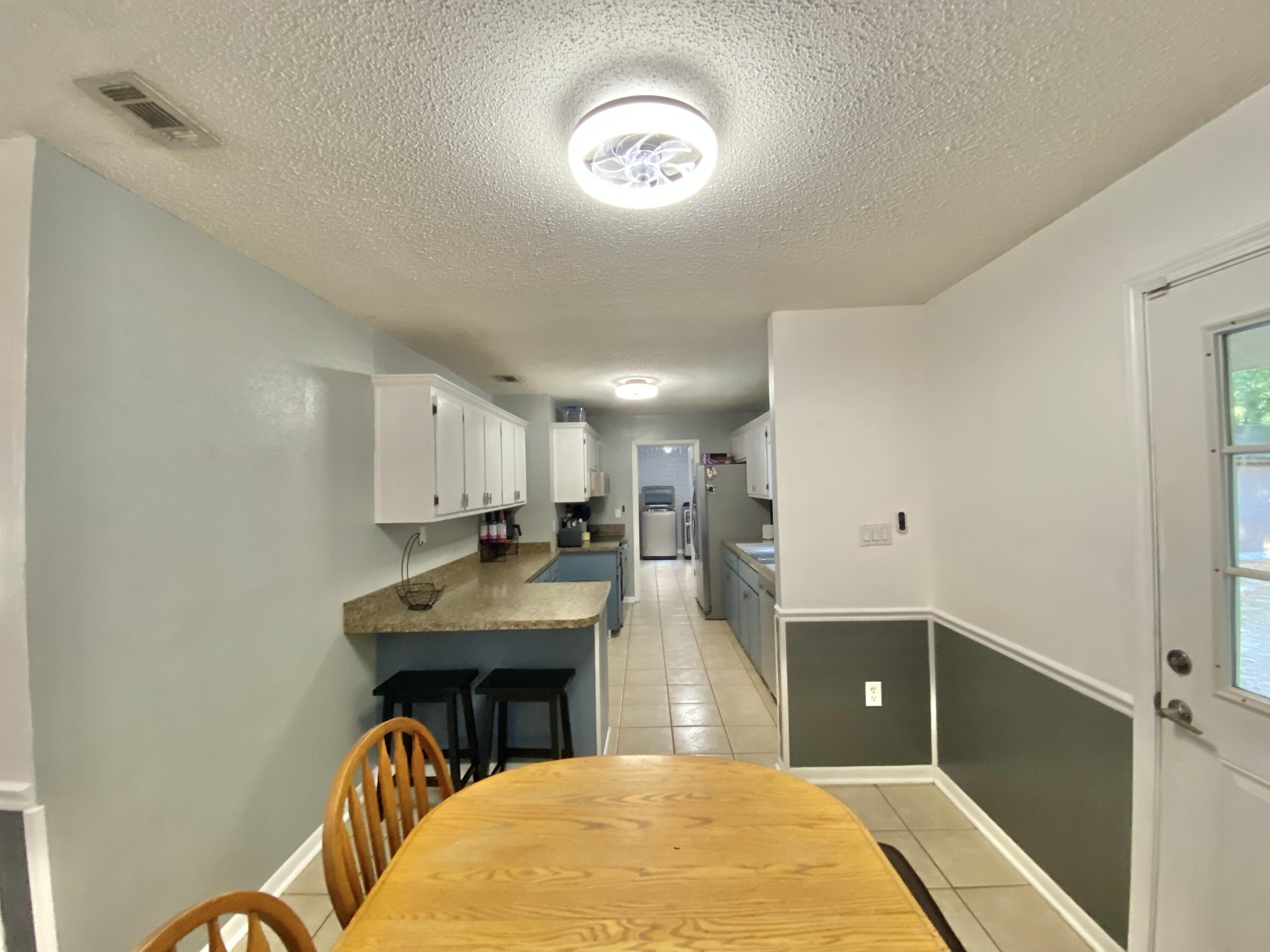 309 Springwood Circle Crestview, FL 32536 - Photo 12 of 44 a kitchen with kitchen island a stove and a sink