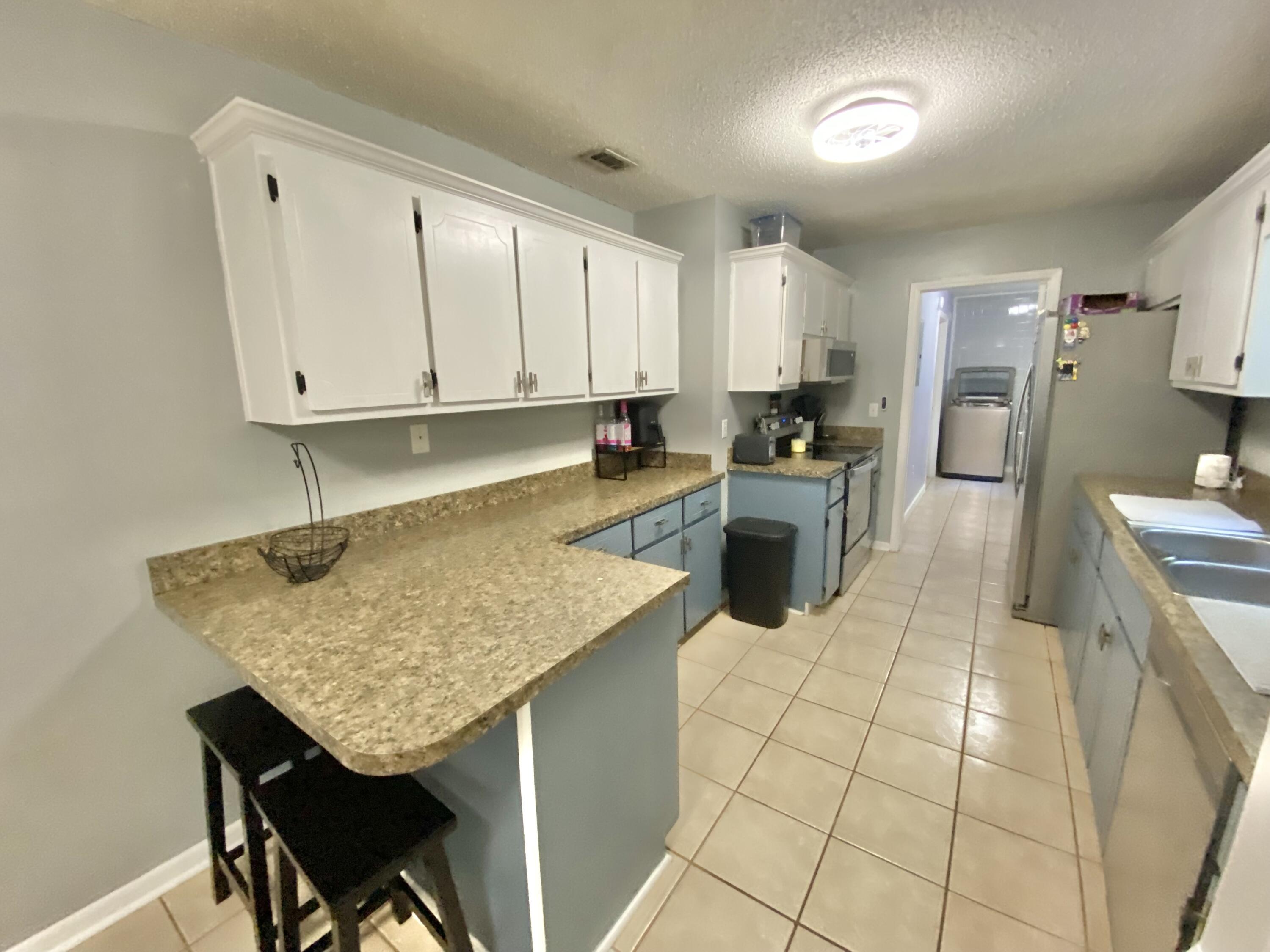 309 Springwood Circle Crestview, FL 32536 - Photo 15 of 44 a kitchen with stainless steel appliances granite countertop a sink counter space and cabinets
