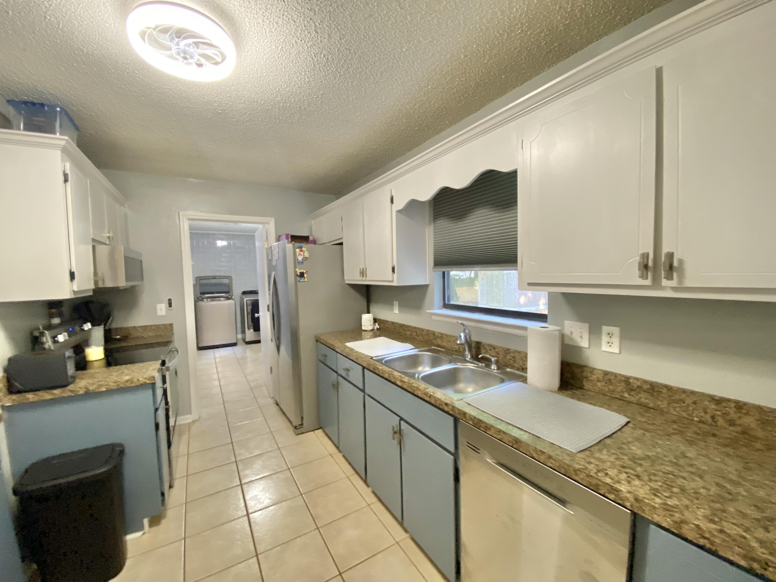 309 Springwood Circle Crestview, FL 32536 - Photo 16 of 44 a kitchen with a sink stove and cabinets