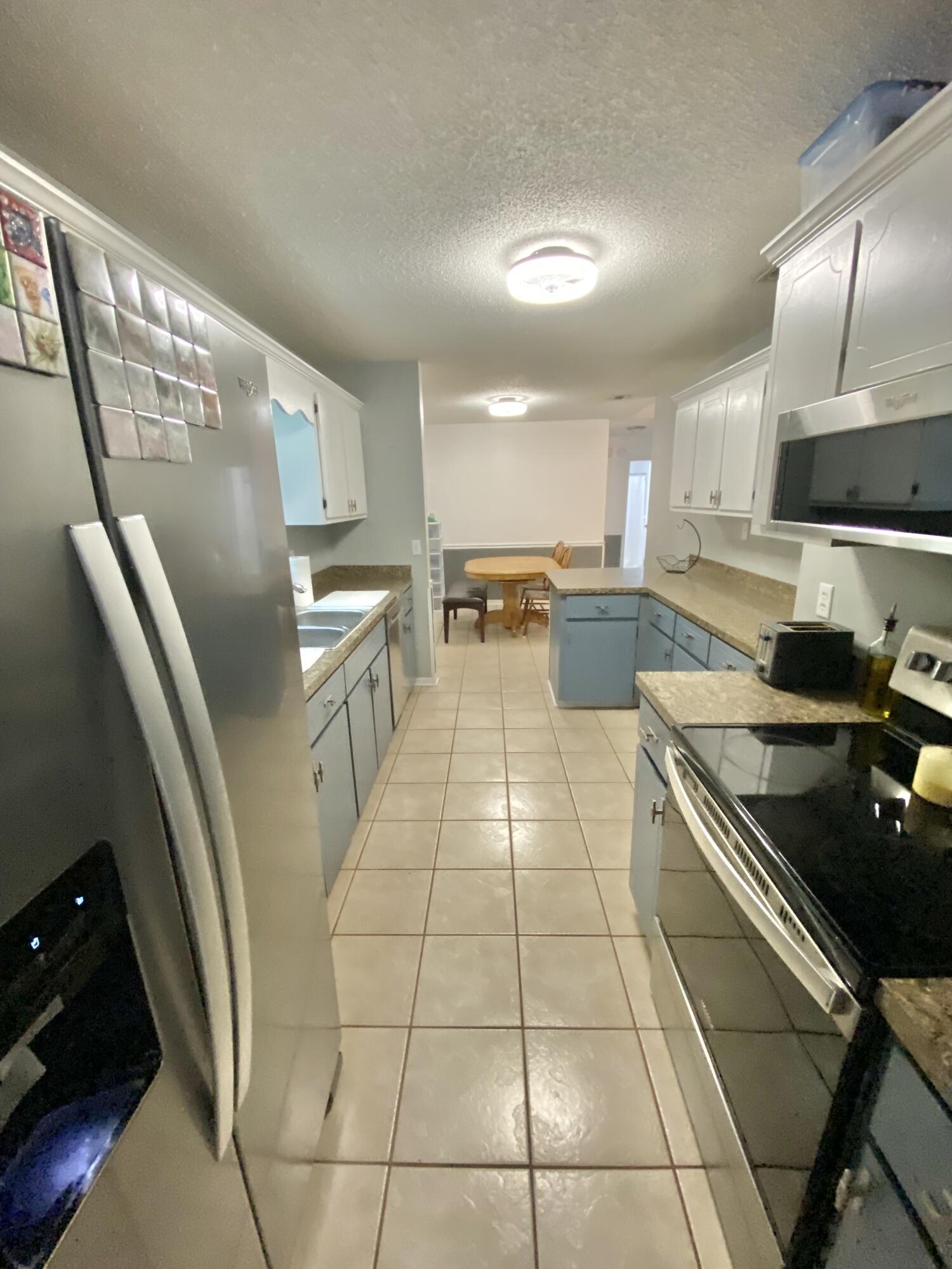 309 Springwood Circle Crestview, FL 32536 - Photo 17 of 44 a kitchen with stainless steel appliances granite countertop a sink stove and cabinets