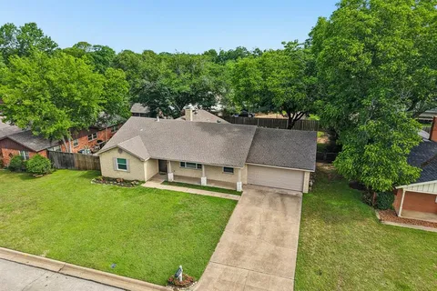 a aerial view of a house with swimming pool next to a big yard