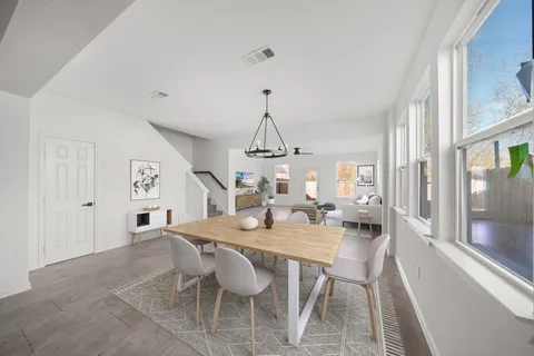 a dining room with wooden floor a chandelier a wooden table and chairs