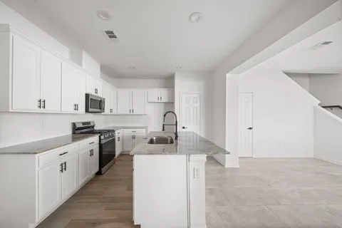 a kitchen with white cabinets appliances and a sink