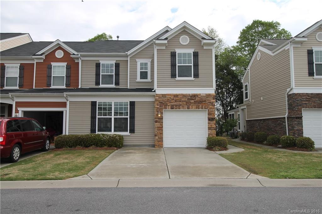 a front view of a house with a garden and garage