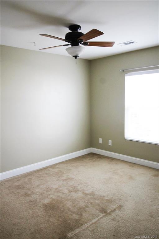 242 River Clay Road, Unit UNTI 202 Fort Mill, SC 29708 - Photo 18 of 18 an empty room with a ceiling fan and window