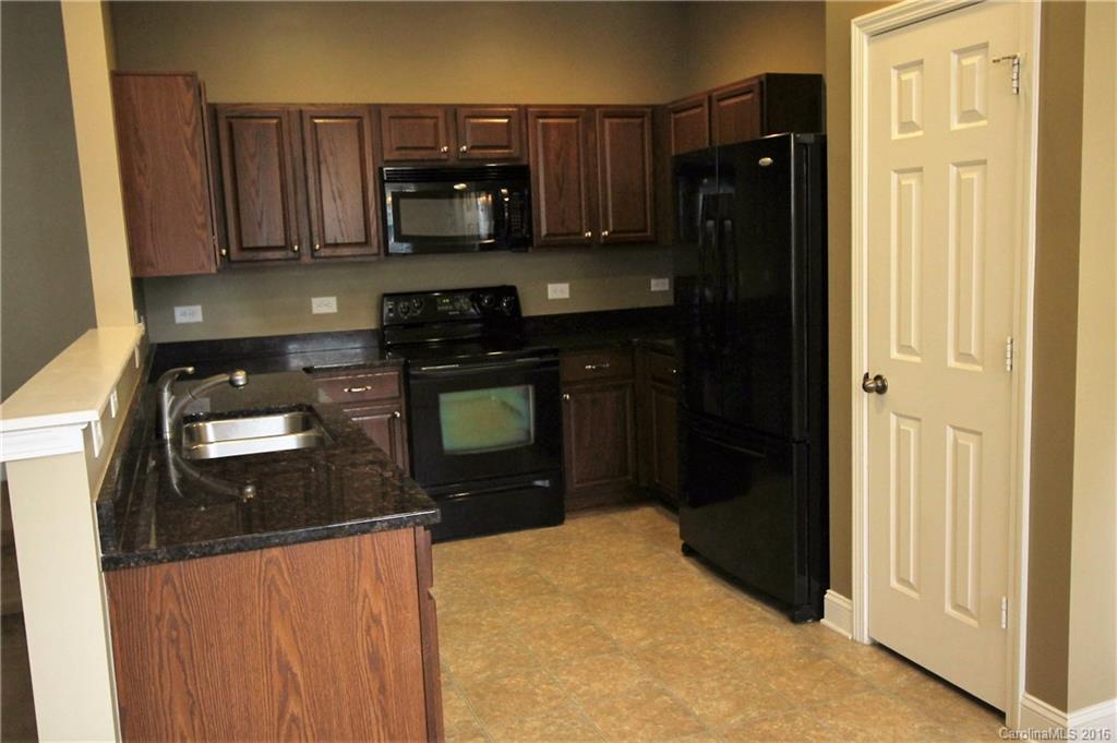 242 River Clay Road, Unit UNTI 202 Fort Mill, SC 29708 - Photo 5 of 18 a kitchen with stainless steel appliances granite countertop a refrigerator and a stove top oven