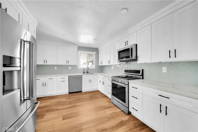 a kitchen with granite countertop a sink cabinets and wooden floor