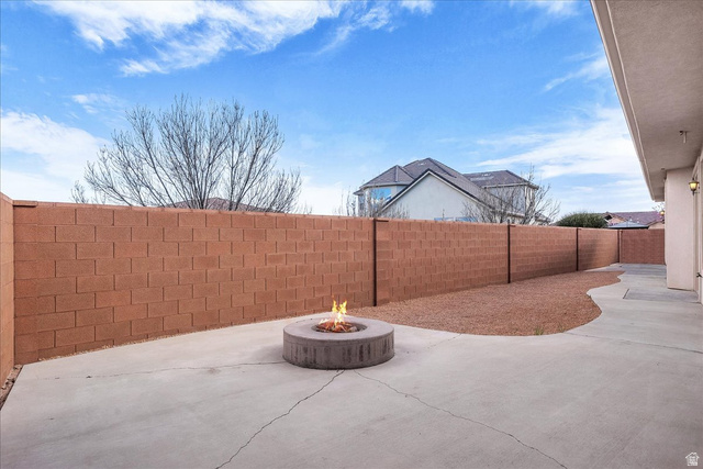 691 Rainier Drive St. George, UT 84770 - Photo 17 of 24 Fenced backyard featuring a patio area and an outdoor fire pit