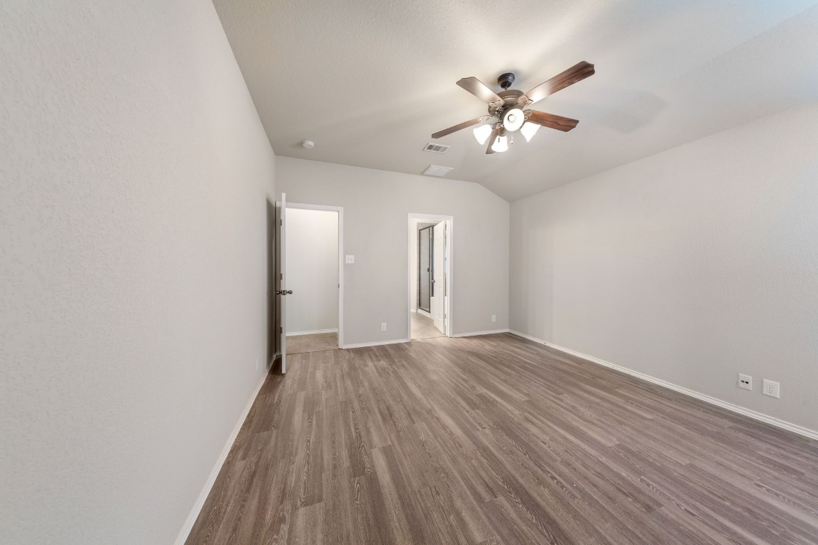 1811 Conn Creek Road Cedar Park, TX 78613 - Photo 24 of 33 a view of an empty room with wooden floor and a ceiling fan