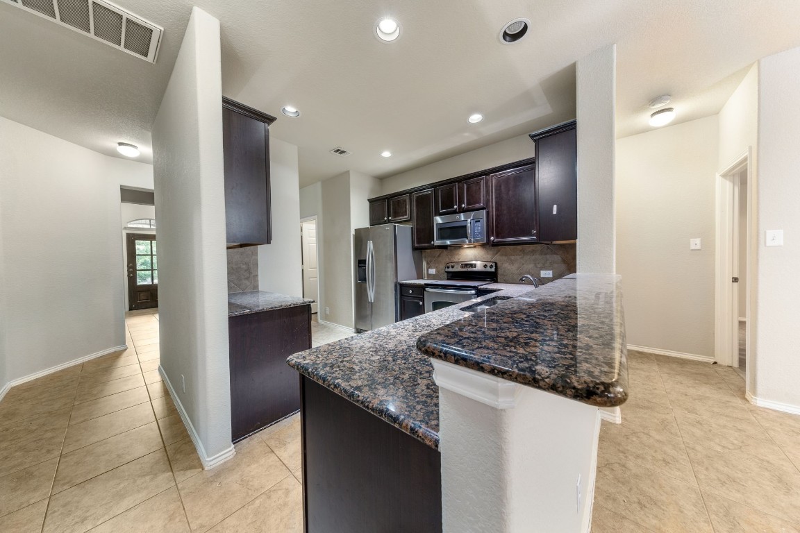 1811 Conn Creek Road Cedar Park, TX 78613 - Photo 8 of 33 a kitchen with stainless steel appliances granite countertop a refrigerator and a sink