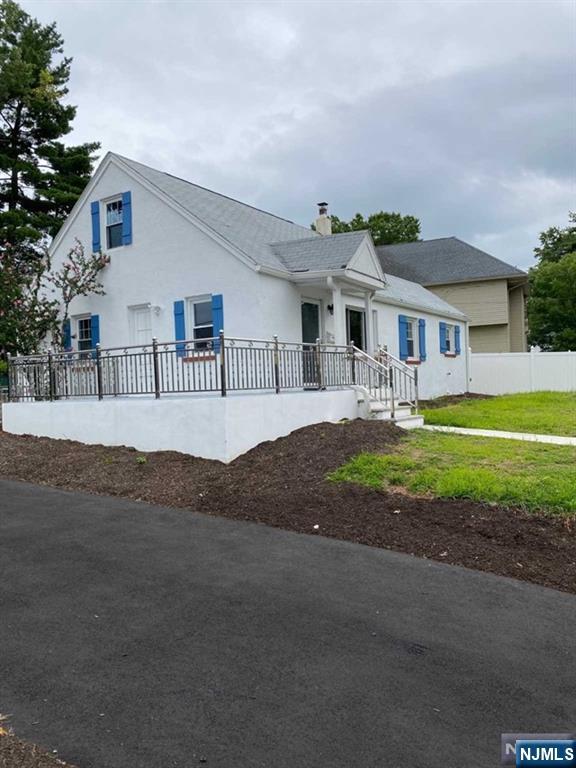a front view of a house with a garden and trees