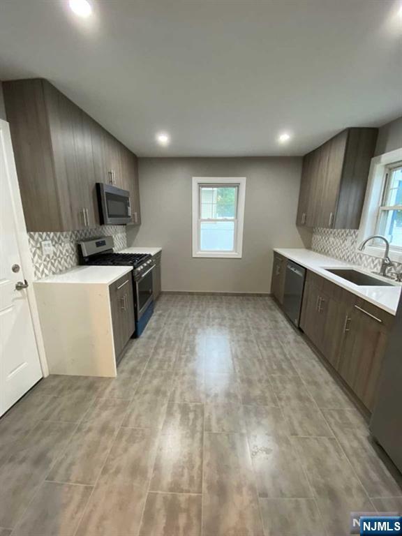79 East Ridgewood Avenue Paramus, NJ 07652 - Photo 7 of 31 a view of a kitchen with a sink wooden cabinets and stainless steel appliances