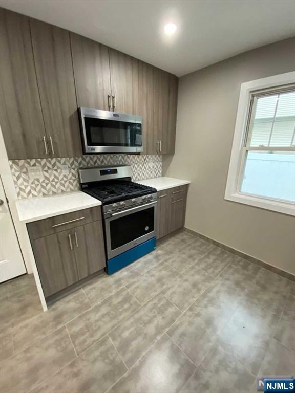 79 East Ridgewood Avenue Paramus, NJ 07652 - Photo 8 of 31 a kitchen with stainless steel appliances granite countertop a stove a sink and a microwave