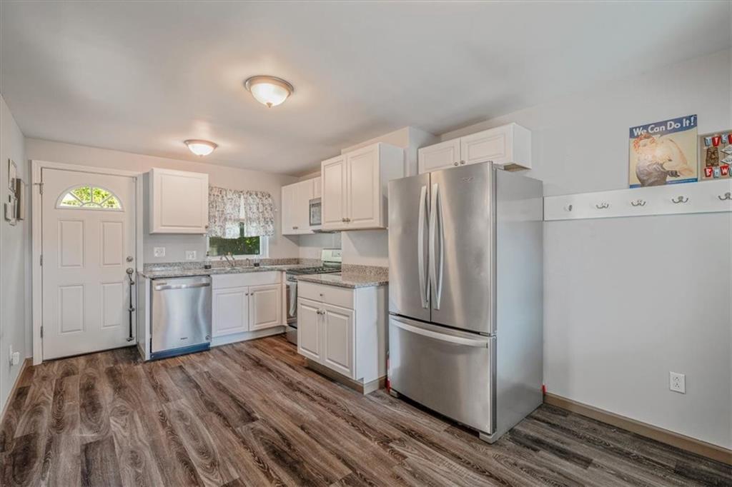 559 Boquet Street Carnegie, PA 15106 - Photo 3 of 20 a kitchen with a refrigerator wooden floor and white cabinets