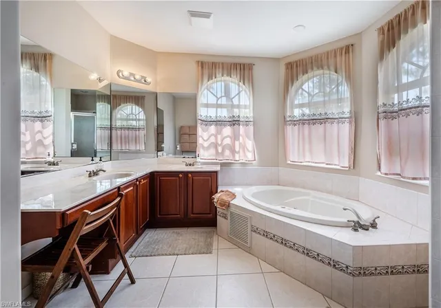 a spacious bathroom with a granite countertop tub sink and mirror
