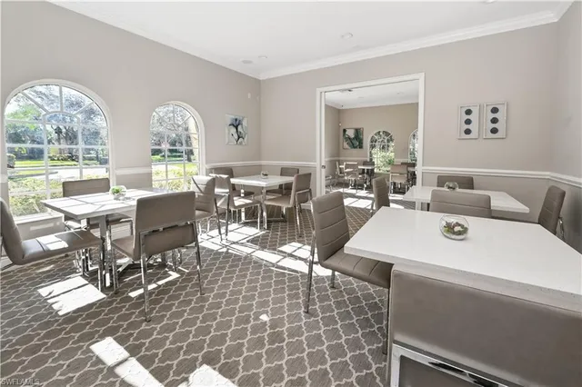 a living room with patio furniture and a large window