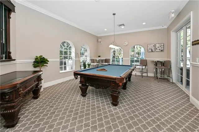a room with pool table furniture and windows