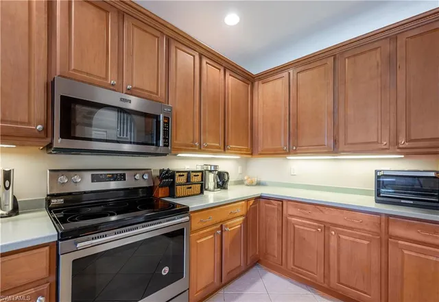 a kitchen with stainless steel appliances granite countertop a sink a stove a microwave oven and cabinets