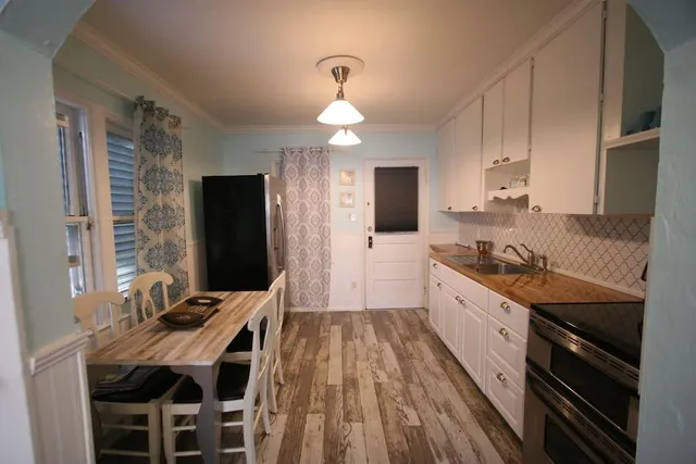 a large kitchen with granite countertop a stove refrigerator a sink dishwasher with a dining table and chair