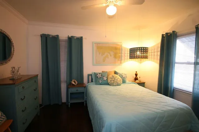 a bedroom with a bed and a flat tv screen on dresser