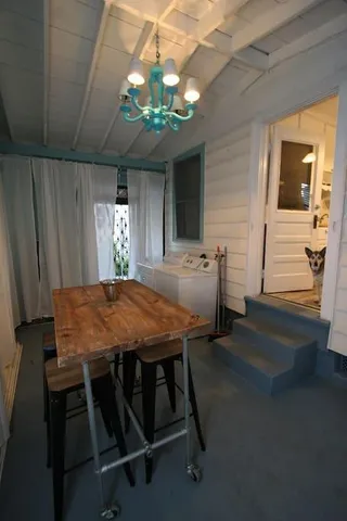 a dining room with wooden floor a chandelier a wooden table and chairs