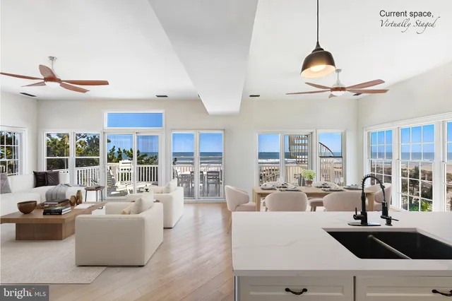 a living room with furniture ceiling fan and a large window
