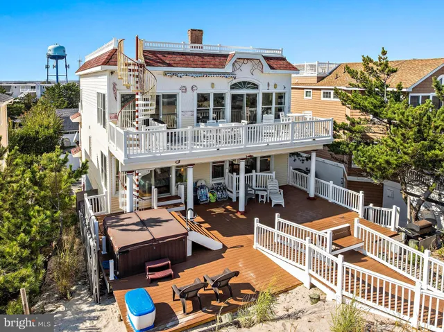 a large kitchen with stainless steel appliances granite countertop a stove a sink dishwasher a refrigerator white cabinets wooden floor and a granite counter top