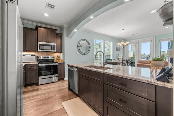 a kitchen with stainless steel appliances granite countertop a stove a sink and a refrigerator