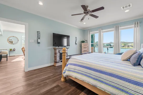 a bedroom with a bed and a flat screen tv with wooden floor