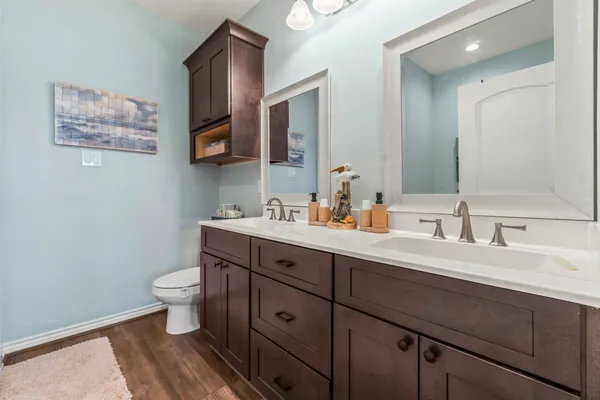 a bathroom with a double vanity sink toilet and a mirror