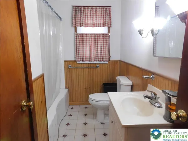 a bathroom with a sink a toilet and shower curtain