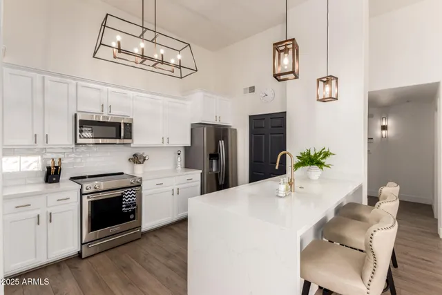 a kitchen with white cabinets and appliances