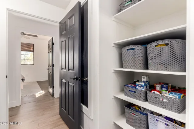 a kitchen with stainless steel appliances a white refrigerator a stove a sink dishwasher a dining table and chairs with wooden floor