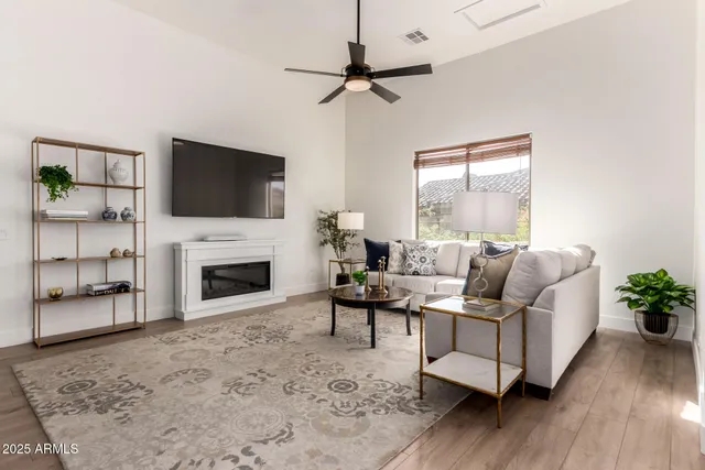 a living room with furniture a flat screen tv and a fireplace