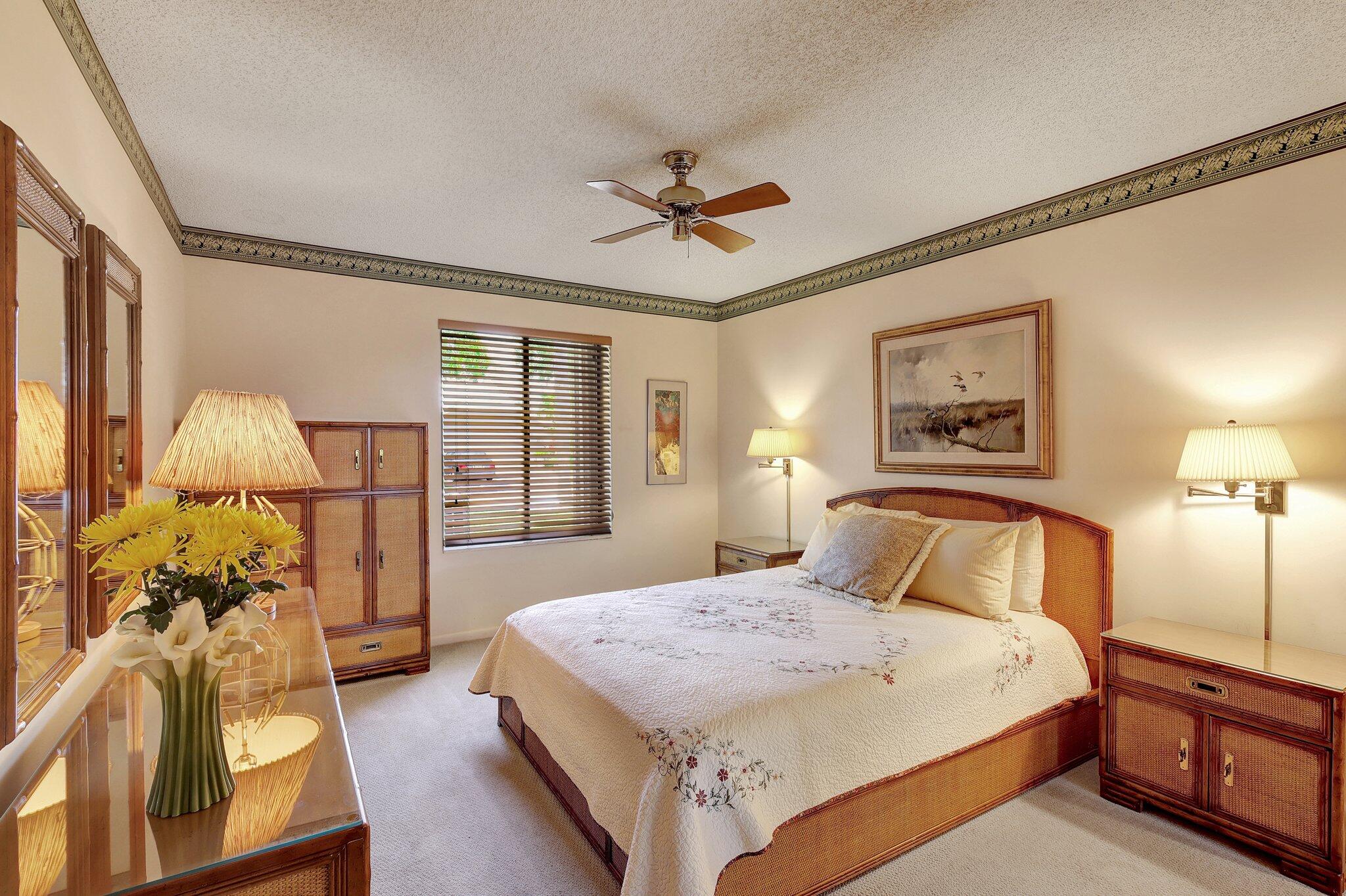 315 Ridge Road Jupiter, FL 33477 - Photo 21 of 42 a bedroom with a large bed and a chandelier
