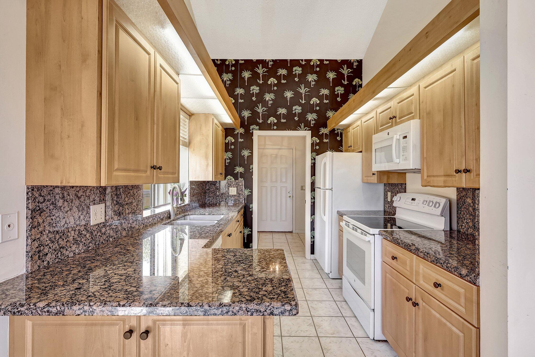 315 Ridge Road Jupiter, FL 33477 - Photo 8 of 42 a kitchen with stainless steel appliances granite countertop a sink stove and refrigerator