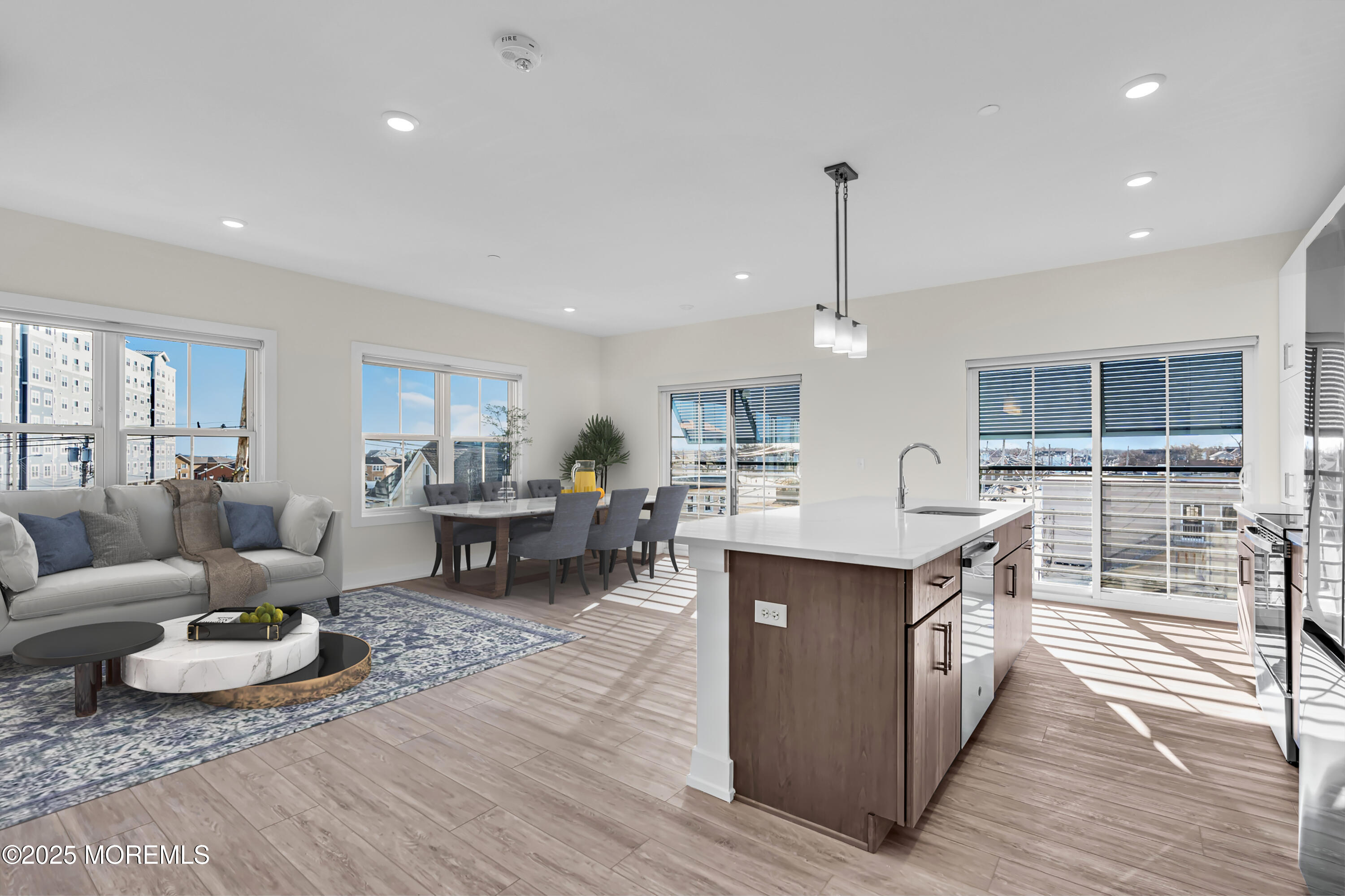a living room with furniture a wooden floor and kitchen view