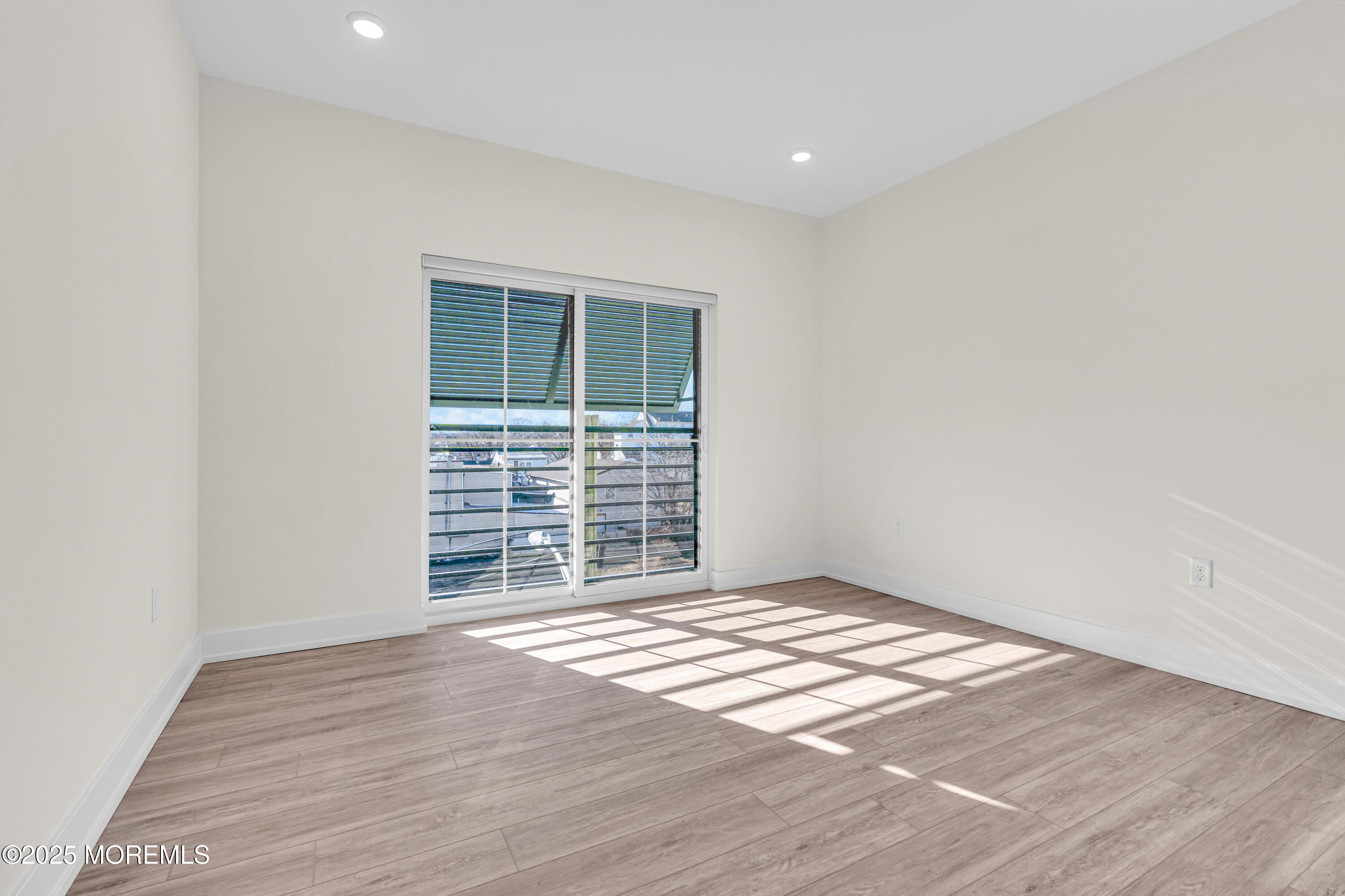 19 Carr Avenue, Unit 219 Keansburg, NJ 07734 - Photo 11 of 22 an empty room with wooden floor and windows