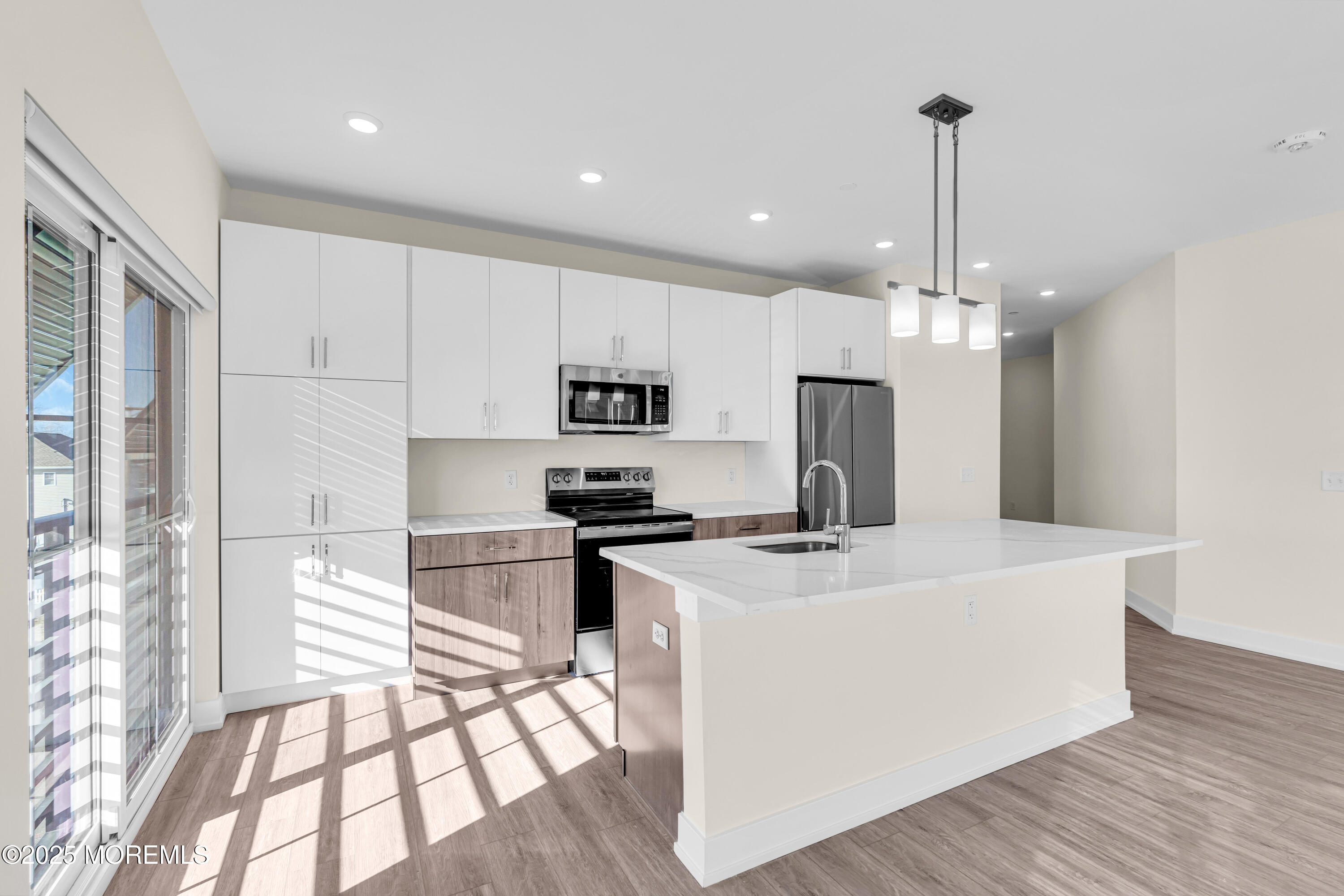 19 Carr Avenue, Unit 219 Keansburg, NJ 07734 - Photo 5 of 22 a kitchen with stainless steel appliances kitchen island granite countertop a refrigerator a sink dishwasher a stove and white cabinets with wooden floor